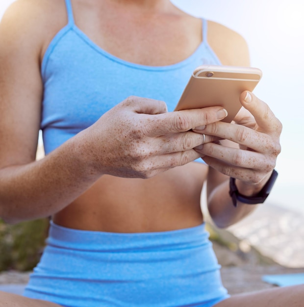 Vrouw handen fitness app en telefoon buiten typen in workout video's oefening tutorial en workout muziek afspeellijst Close-up yoga meisje sociale media mobiele melding en online virtuele coach lezen