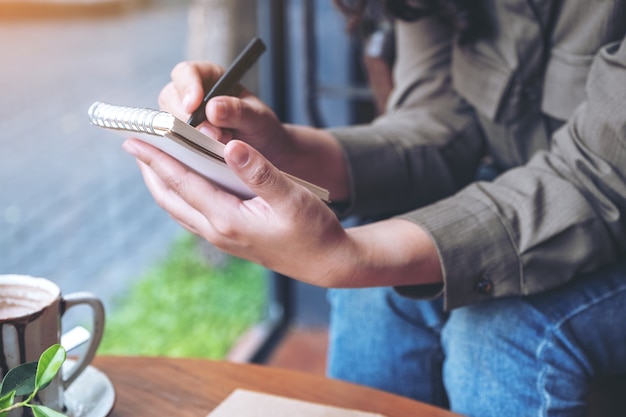 vrouw handen houden en schrijven op lege notebook