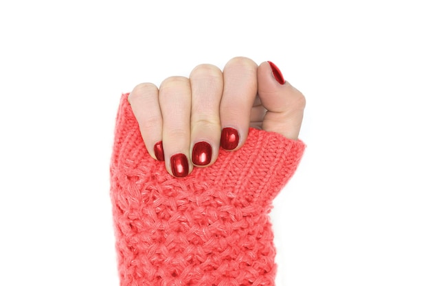 Vrouw handen in gele trui met vers gelakte nagels en rode winter Kerst Nieuwjaar manicure