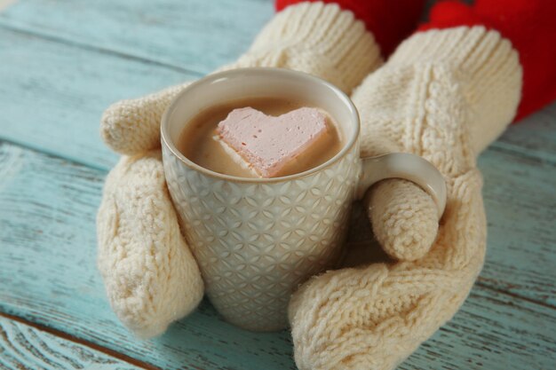 Vrouw handen in wanten met een kopje koffie