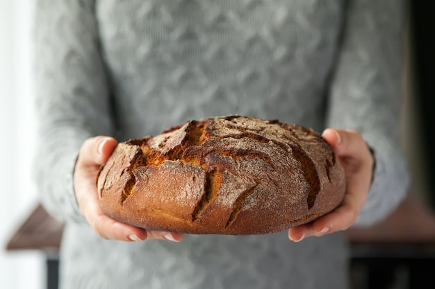 Vrouw handen met een mooi rond roggebrood