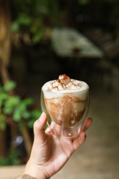 Vrouw handen met kopje koffie met latte art kopje thee of koffie in de ochtend