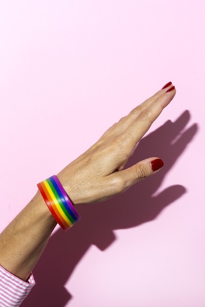 Vrouw handen met lgbt armband op roze achtergrond