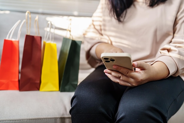 Vrouw handen met mobiele telefoon met behulp van smartphonexAsale boodschappentassen consumentisme levensstijl concept in het winkelcentrum met boodschappentas