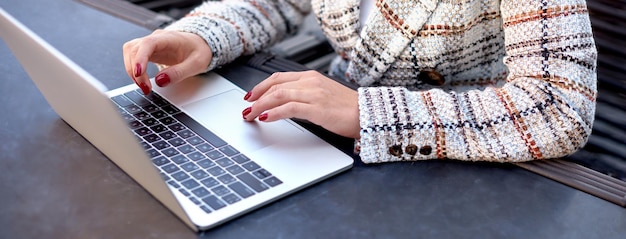 Vrouw handen met rode manicure typen op laptop toetsenbord Communicatie werkplek bedrijfsonderwijs