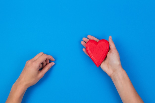 Vrouw handen met rood houten hart