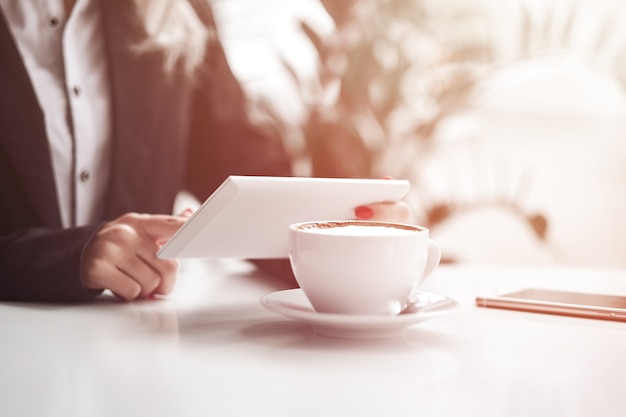 Vrouw handen met slimme telefoon, koptelefoon en kopje thee. voor montage van grafische weergave