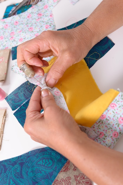 Vrouw handen naaien voor afwerking een dekbed.