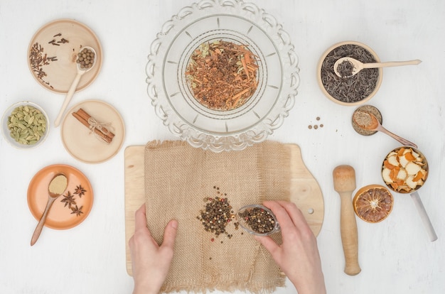 Vrouw handen voorbereiden van Indiase masala thee met kruiden