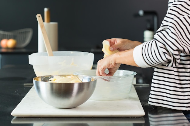 Vrouw handen zetten appels tijdens het koken van appeltaart