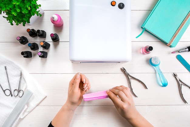 Vrouw handen zorg. Bovenaanzicht van mooie gladde vrouw handen met professionele nagelverzorging Tools voor manicure op witte achtergrond. Detailopname. Bovenaanzicht. Ruimte kopiëren