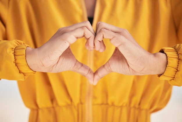 Vrouw hart handen en liefde voor zorg ondersteuning of vertrouwen in de gezondheidszorg romantiek of gebaar Close-up van vrouwelijke persoon met emoji-symbool of pictogram voor gezondheid zoals of wellness in vredesteken of emoticon