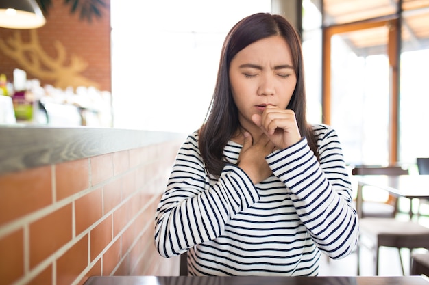 Vrouw heeft keelpijn in het café