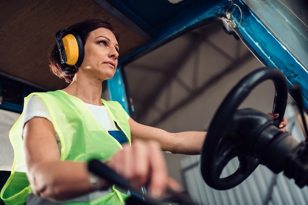 Foto vrouw heftruck operator rijden voertuig