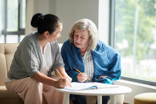 Vrouw helpt vriend met kruiswoordraadsel