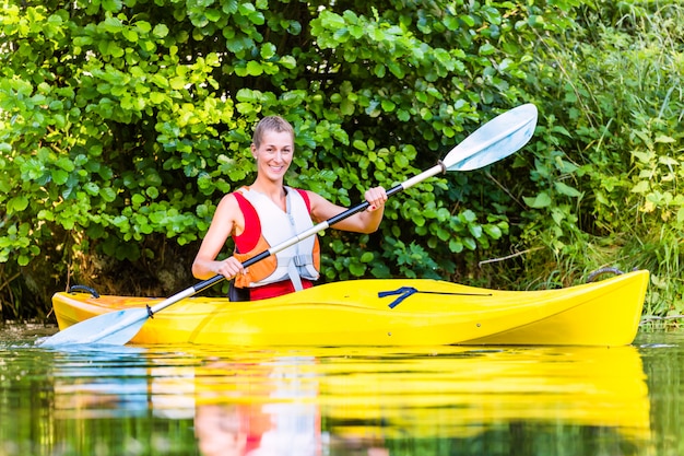 Foto vrouw het drijven met kajak op bosrivier