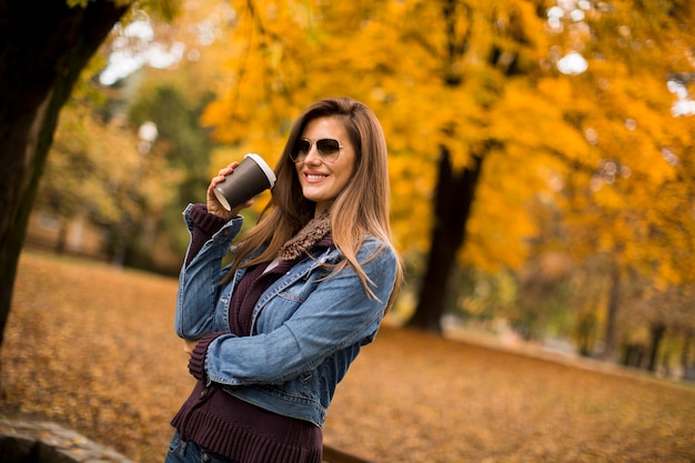 Vrouw het drinken koffie in de herfstpark