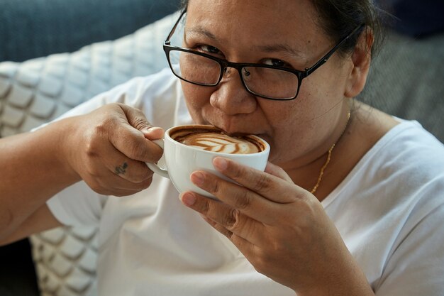 Vrouw het drinken koffie in de koffiewinkel