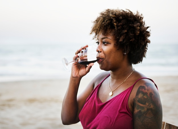 Vrouw het drinken wijn op het strand