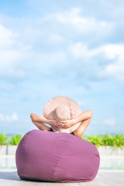 Vrouw het ontspannen door de pool in de zomerdag