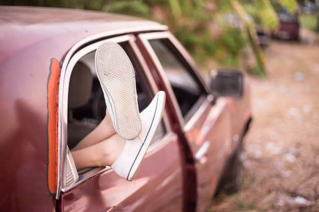 Foto vrouw het ontspannen in haar oldcar terwijl het drijven in het platteland