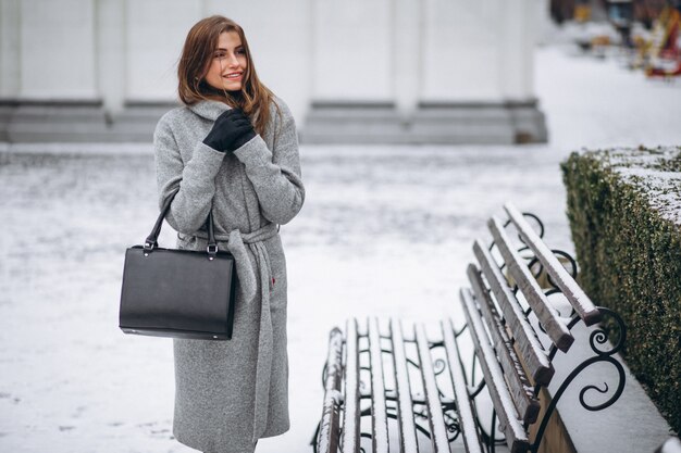 Vrouw het stellen in grijze laag buiten in de winter