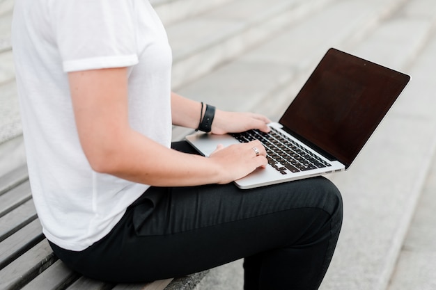 Vrouw het typen op laptop toetsenbord op de straat