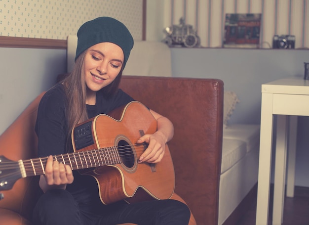 Vrouw hipster spelen op gitaar en genieten van muziek