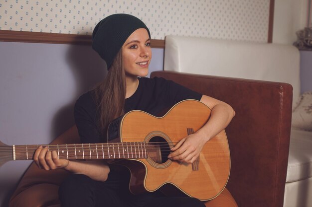 Vrouw hipster spelen op gitaar en genieten van muziek