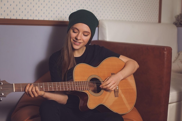 Vrouw hipster spelen op gitaar en genieten van muziek