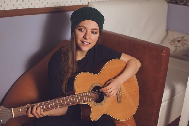 Vrouw hipster spelen op gitaar en genieten van muziek