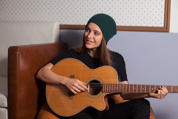 Vrouw hipster spelen op gitaar en zingen