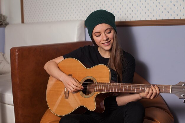 Vrouw hipster spelen op gitaar en zingen