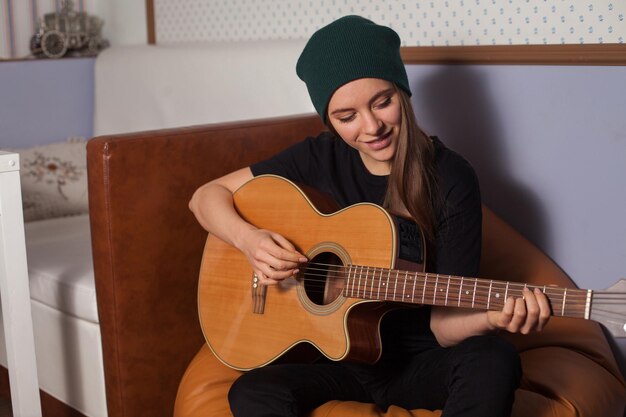Vrouw hipster spelen op gitaar en zingen