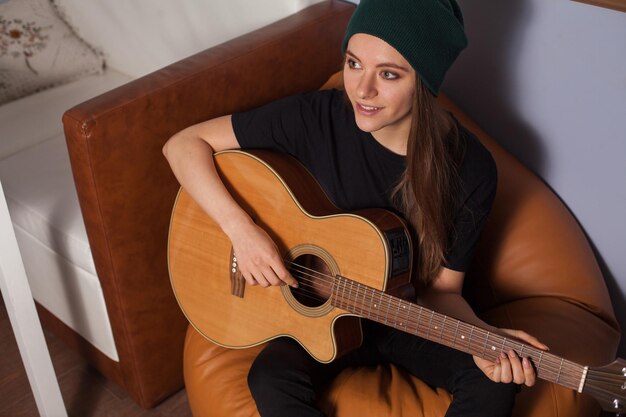 Vrouw hipster spelen op gitaar en zingen