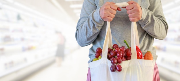 Vrouw houdt boodschappentas vast in supermarkt