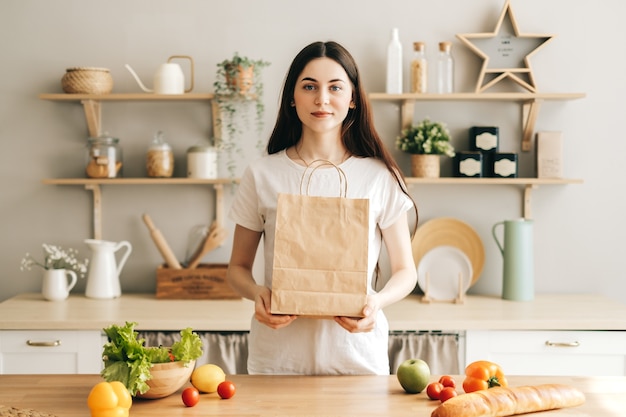 vrouw houdt eco boodschappentas met verse groenten in de keuken