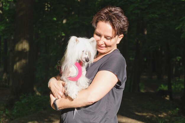 Vrouw houdt een Chinese Naakthond in haar armen