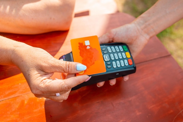vrouw houdt een draadloze bankbetaalterminal vast om de creditcard te verkrijgen in winkelcafé-restaur