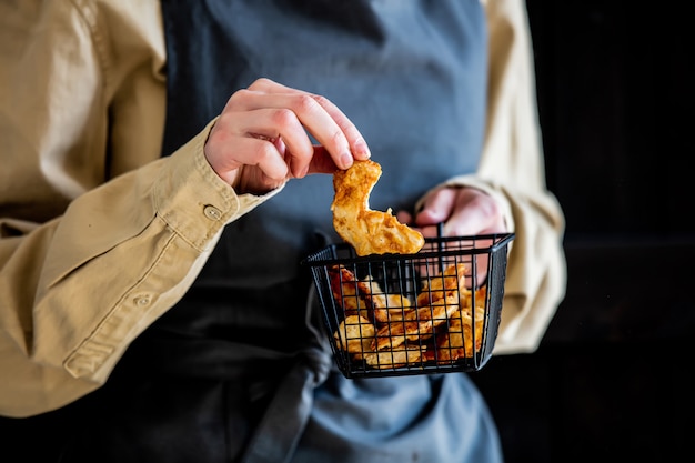 Vrouw houdt een gebakken kippenborst