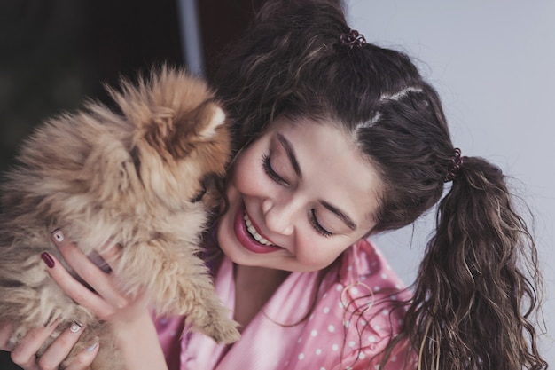 Foto vrouw houdt een kleine hond in de kamer