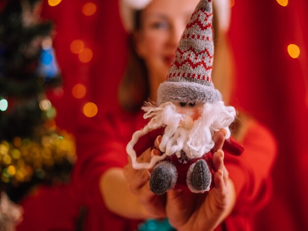 Vrouw houdt een Santa speelgoed. Kerst muur