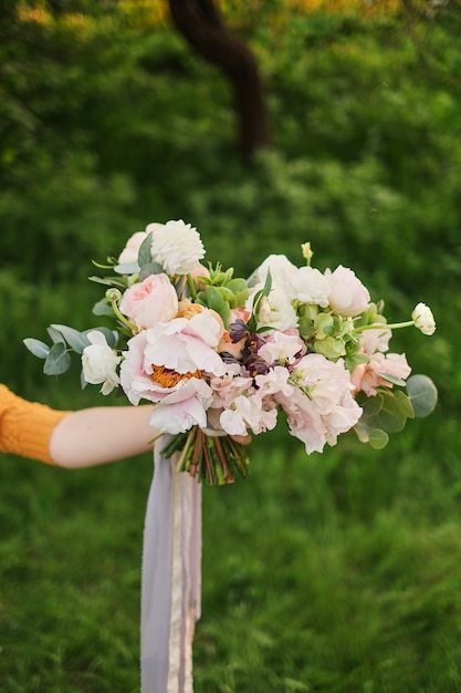 Foto vrouw houdt in haar hand een mooie bruiloft boeket