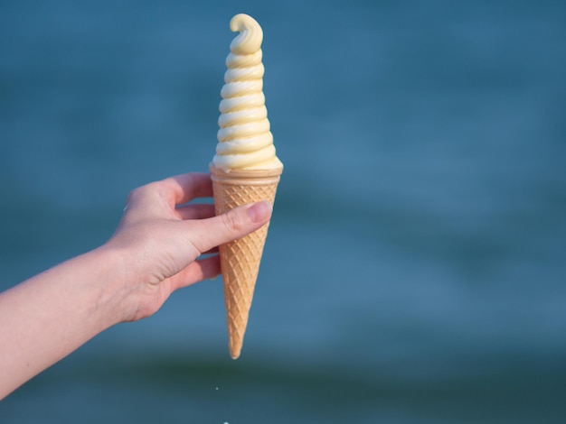 Vrouw houdt lekker ijs op het strand.