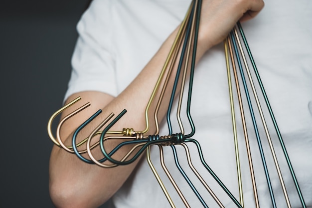 Vrouw houdt metalen kleerhangers in handen