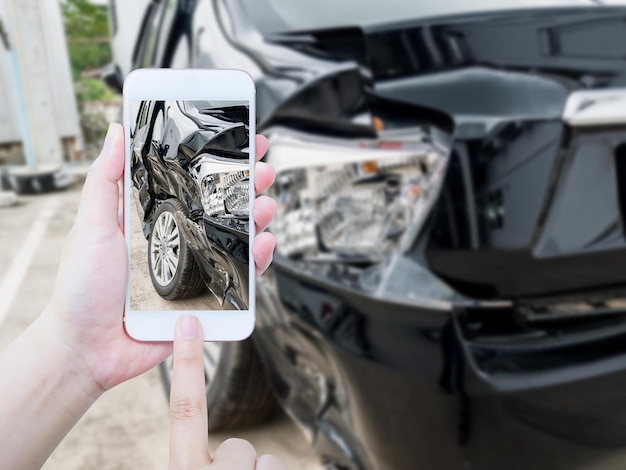 Vrouw houdt mobiele smartphone vast die auto-ongeluk fotografeert voor verzekering