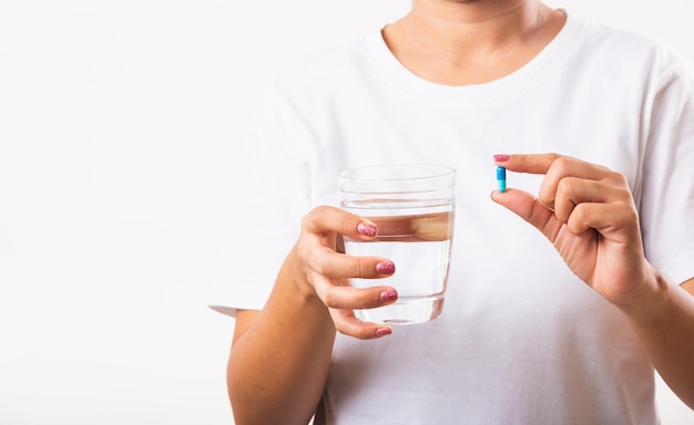 vrouw houdt pil medicijnen in de hand klaar neem medicijnen met een glas water