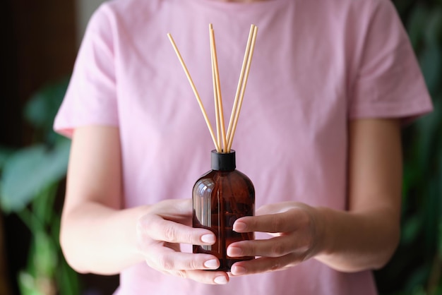 Vrouw houdt pot met een aromatische diffuser van zelfgemaakte geur in handen