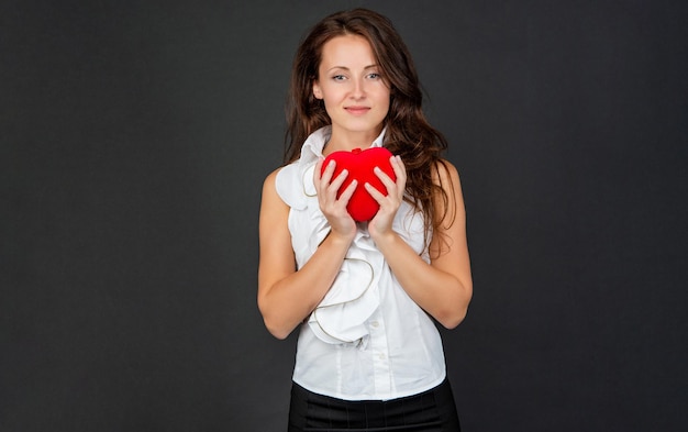 Vrouw houdt rood liefdeshart op zwarte achtergrond, Valentijnsdag.