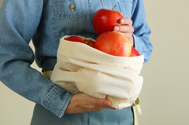 Vrouw houdt tas met rijpe rode appels vast